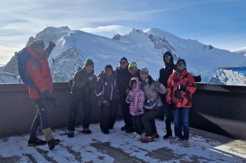 A group of people on a snowy platform with a mountain in the background. 3