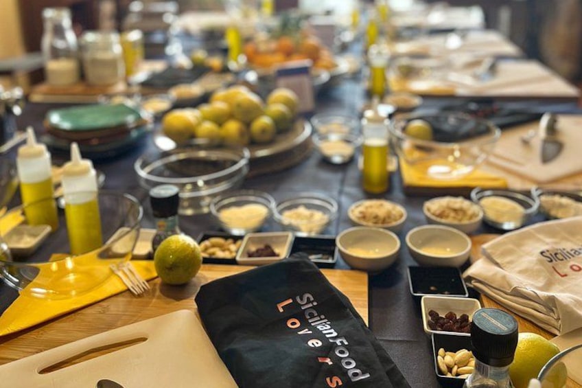 A table with various food items and condiments, including bowls of nuts, lemons, and bottles of sauces. 4