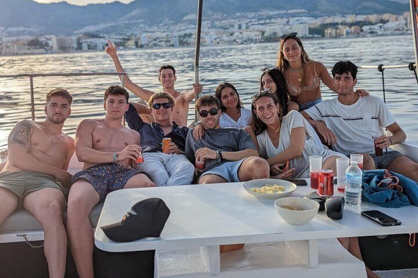 A group of people on a boat with a cityscape in the background. 4