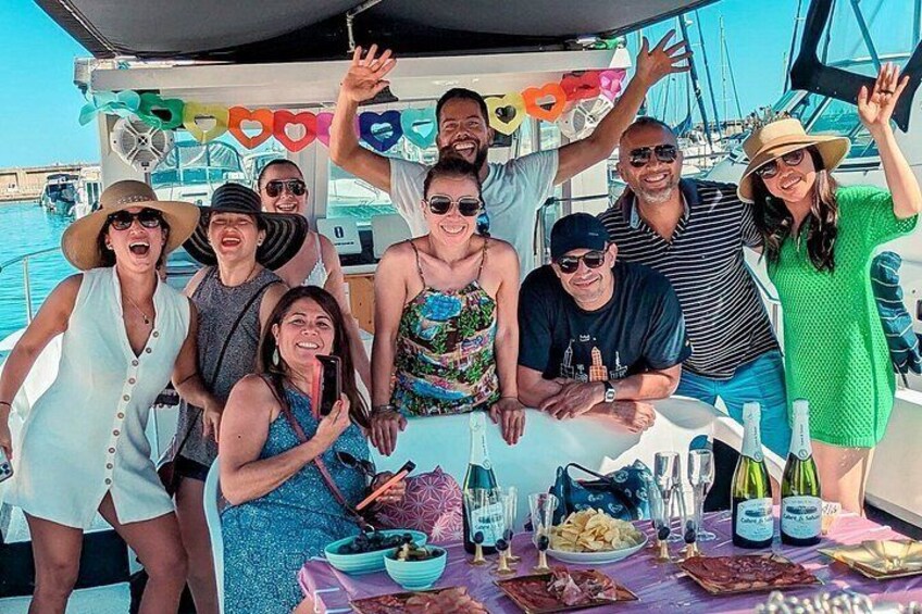 A group of people on a boat with a table of food and drinks. 5