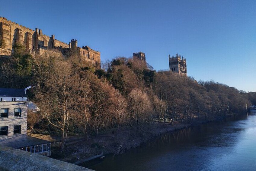A river with a castle on a hill, trees, and a bridge. 5