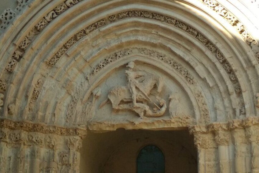 Un arc en pierre finement travaillé, orné de sculptures complexes, et surmonté d’une petite statue. 2
