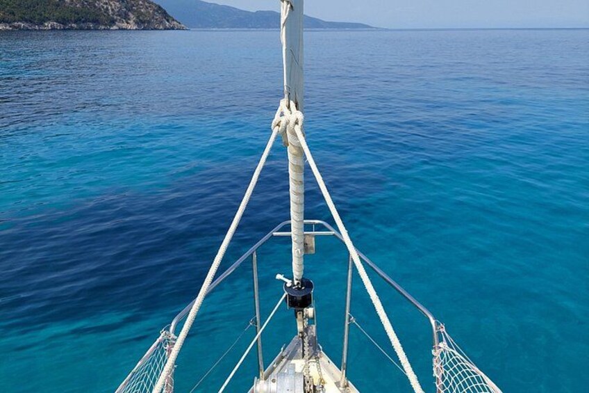 La prua di una barca con corde e sartiame, mare blu calmo e terraferma in lontananza. 4