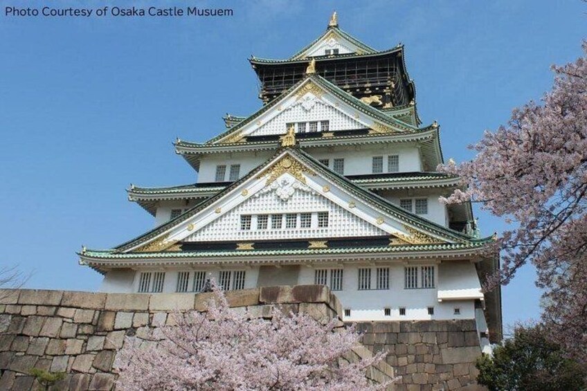 A traditional Japanese castle with multiple tiers, white walls, green roofs, and golden accents. 3