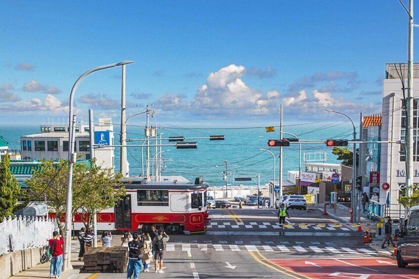 Une rue côtière bordée d’un tramway, de bateaux et d’immeubles. 2
