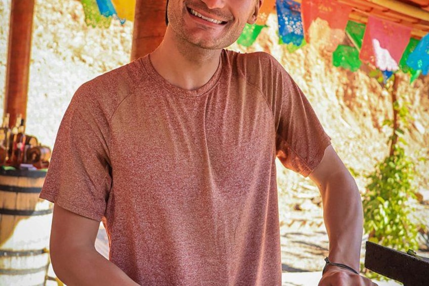 A person wearing a short-sleeved, brown t-shirt standing outdoors. 3