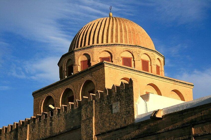 A large dome structure with arched windows and a fortified wall. 3