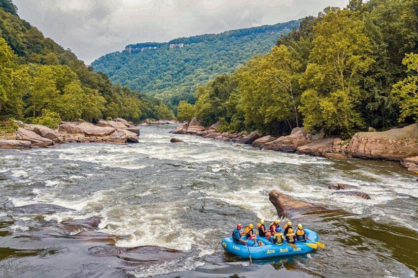 A river with rapids, surrounded by forested hills. 3
