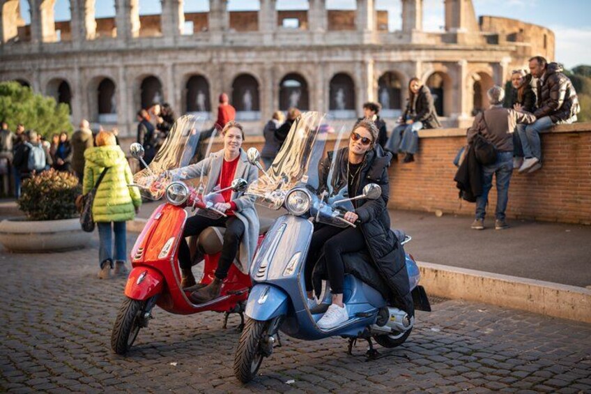 To personer på scootere foran et gammelt amfiteater. 5