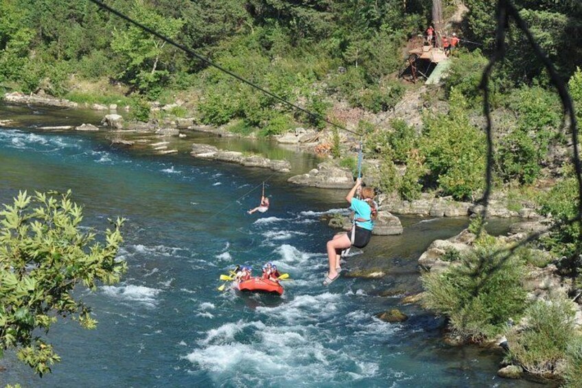 People rafting on a river surrounded by greenery. 1