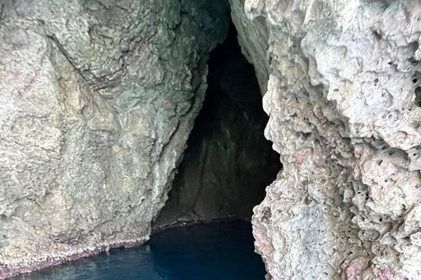 A cave entrance with rough rock walls and a dark interior. 3