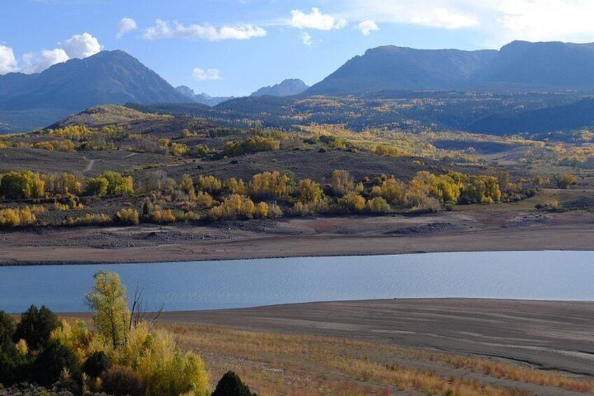 A lake surrounded by hills and sparse vegetation. 3