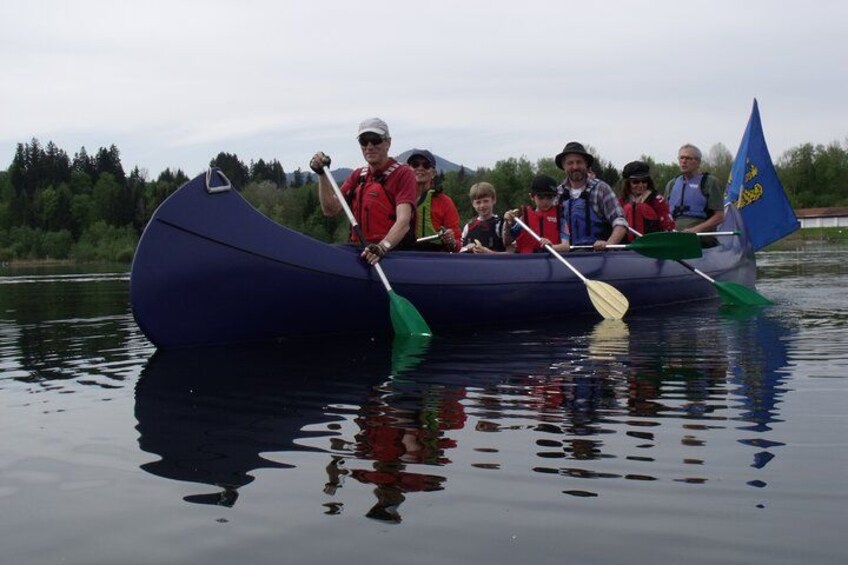 Un grupo de personas en una canoa sobre aguas tranquilas, rodeadas de árboles. 4