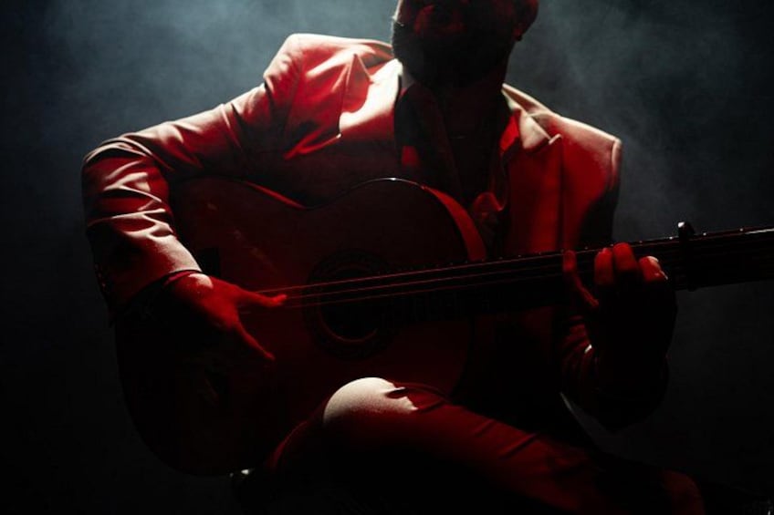 A person playing a guitar in a red suit. 3