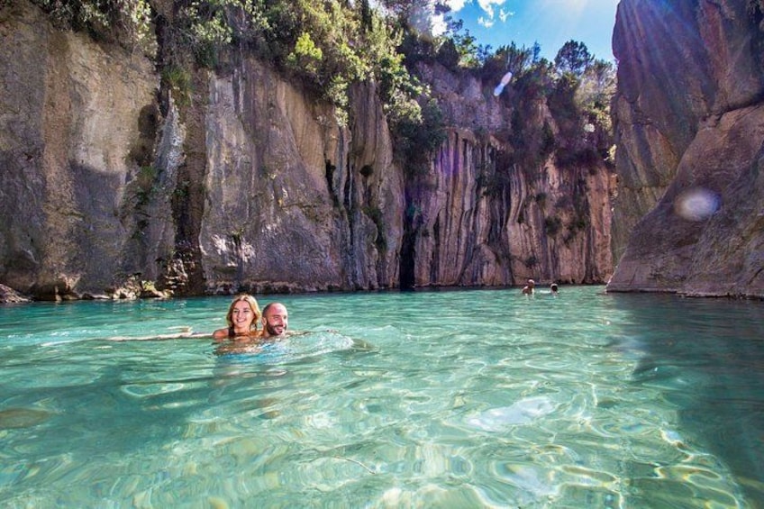A natural water body surrounded by rocky cliffs. 1