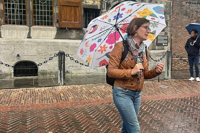 A person walking on a brick pavement with a colorful umbrella. 3