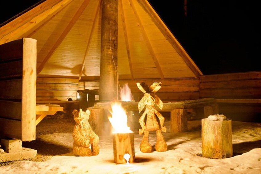A wooden cabin with a fire burning inside. 2