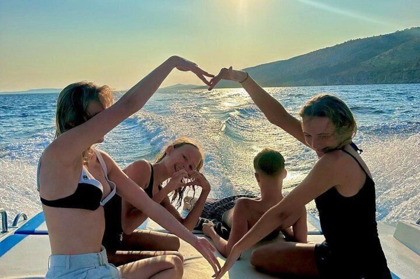 Un groupe de personnes se trouve sur un bateau, naviguant sur une étendue d’eau, avec un paysage vallonné en arrière-plan. 2