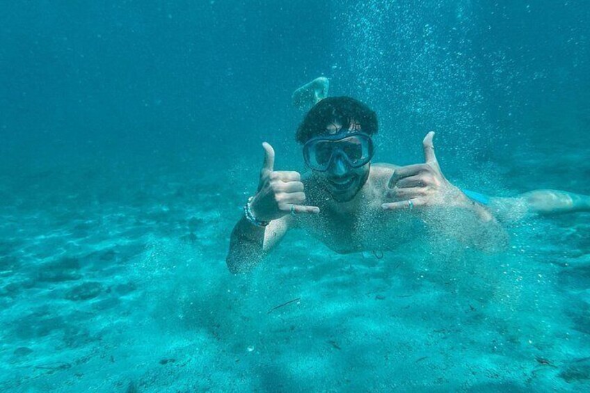 Une personne sous l’eau qui fait un signe de pouce levé. 5