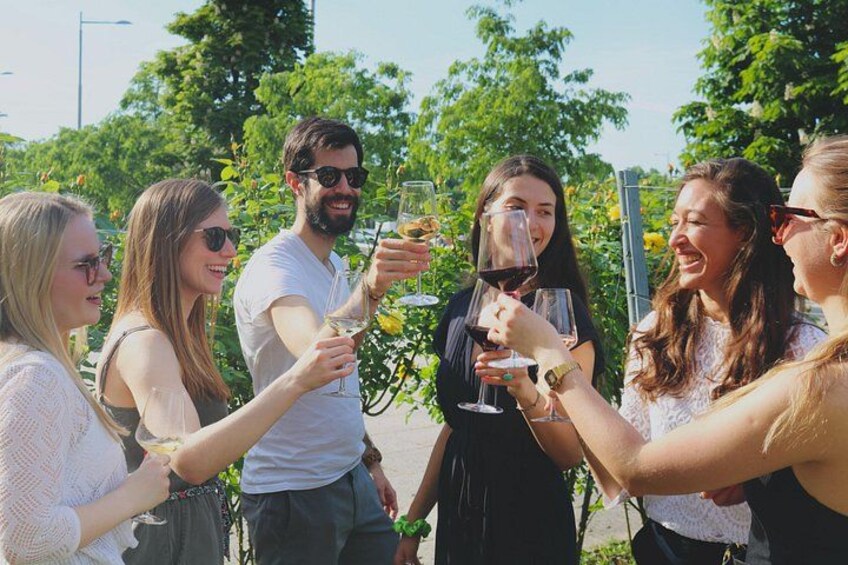 A group of people toasting with wine glasses outdoors. 2