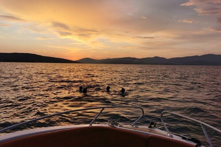 A boat on a lake with a sunset in the background. 3