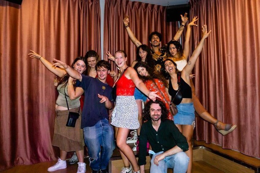 A group of people posing in front of a curtain backdrop. 1