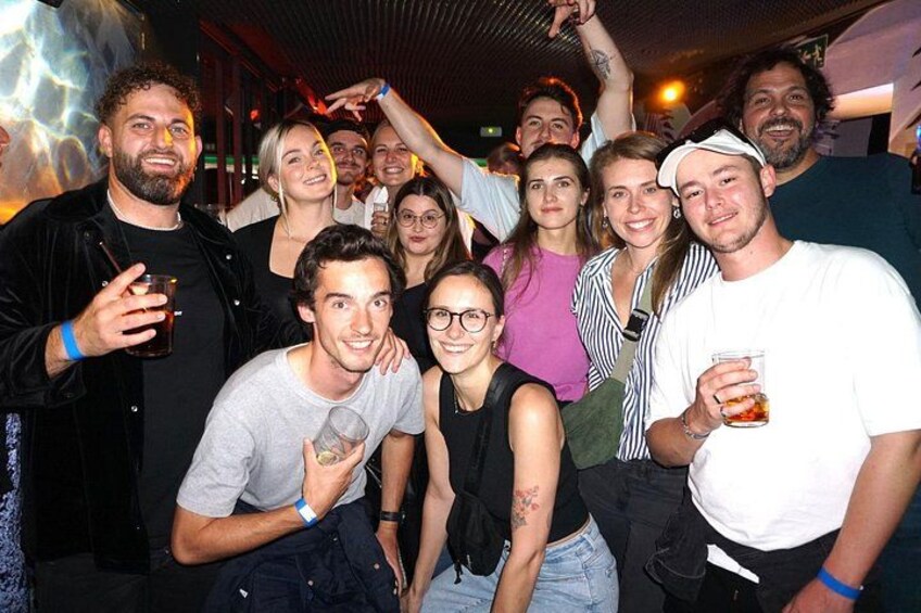 A group of people at a social gathering, some holding drinks. 2