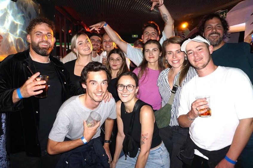 A group of people in a social setting, some holding drinks. 3