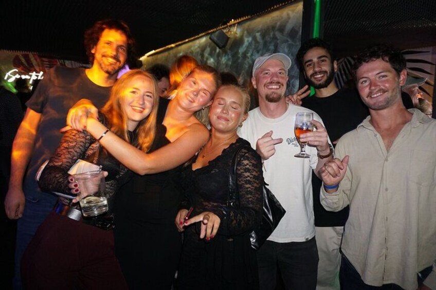 A group of people at a social event, some holding drinks. 4