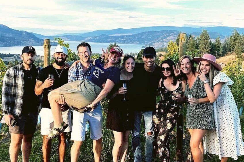 Un grupo de personas de pie al aire libre con un paisaje pintoresco al fondo. 1