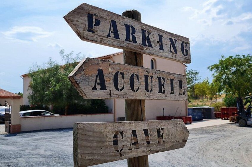 A wooden sign with directions to parking and a cafe. 4