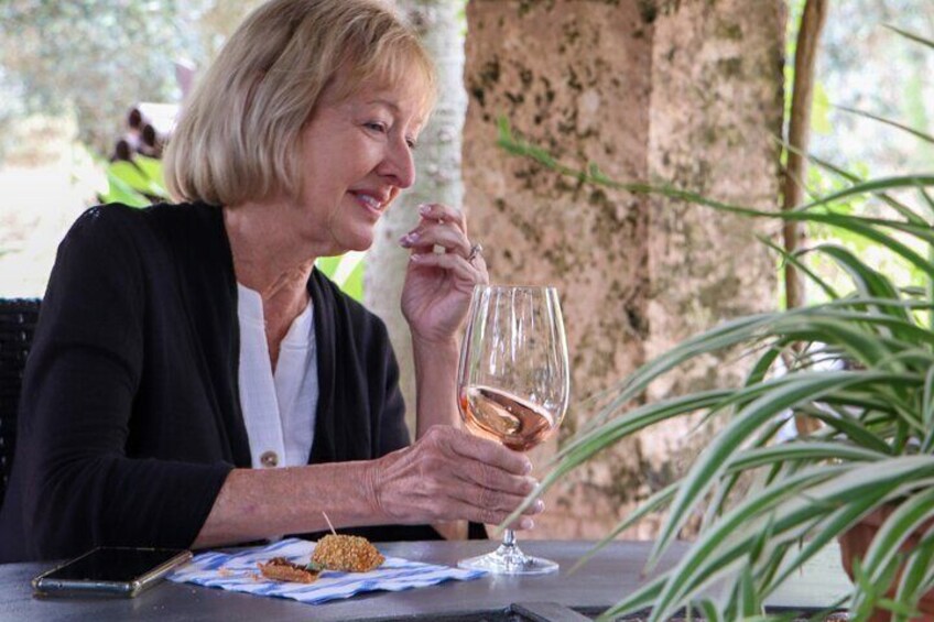 A person holding a wine glass at a table with a blue and white checkered tablecloth. 5