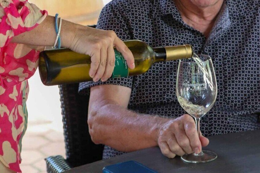 A person pouring wine into a glass. 1