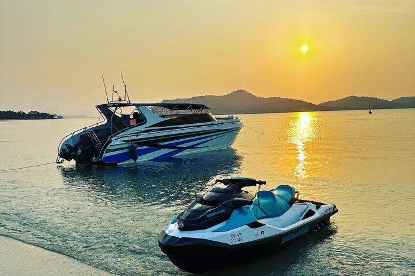En jetski og en båd på roligt vand under solnedgang. 2