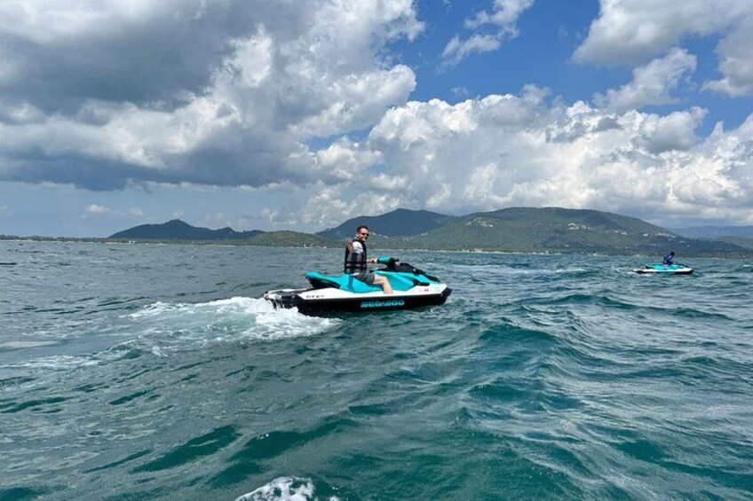 Une personne pratiquant le jet-ski sur une étendue d’eau, avec des montagnes en arrière-plan. 5