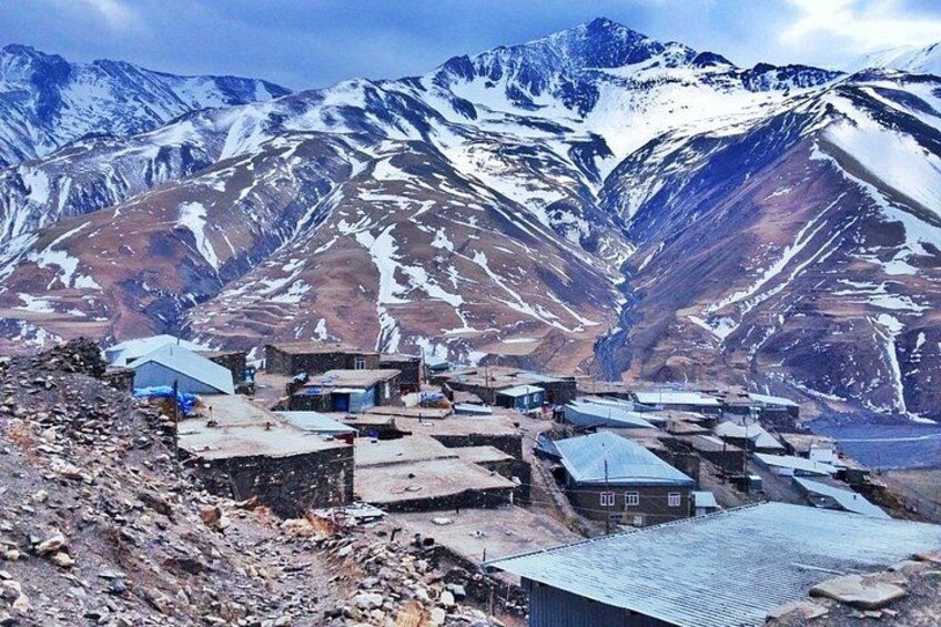 A mountainous village with snow-covered peaks and scattered buildings. 3