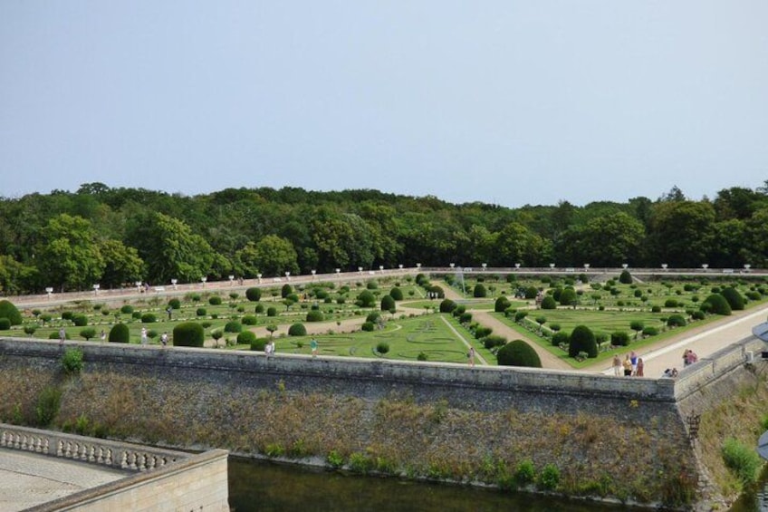 Un jardin à la française, avec des haies taillées en formes géométriques et un élément décoratif aquatique. 4