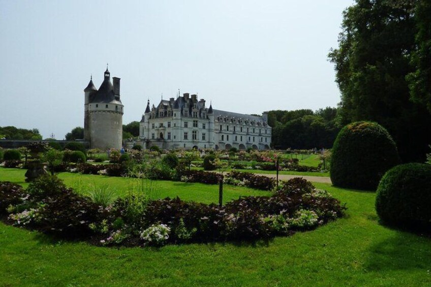 Un château doté d’une tour, entouré de jardins aménagés avec soin et d’un grand bâtiment. 5
