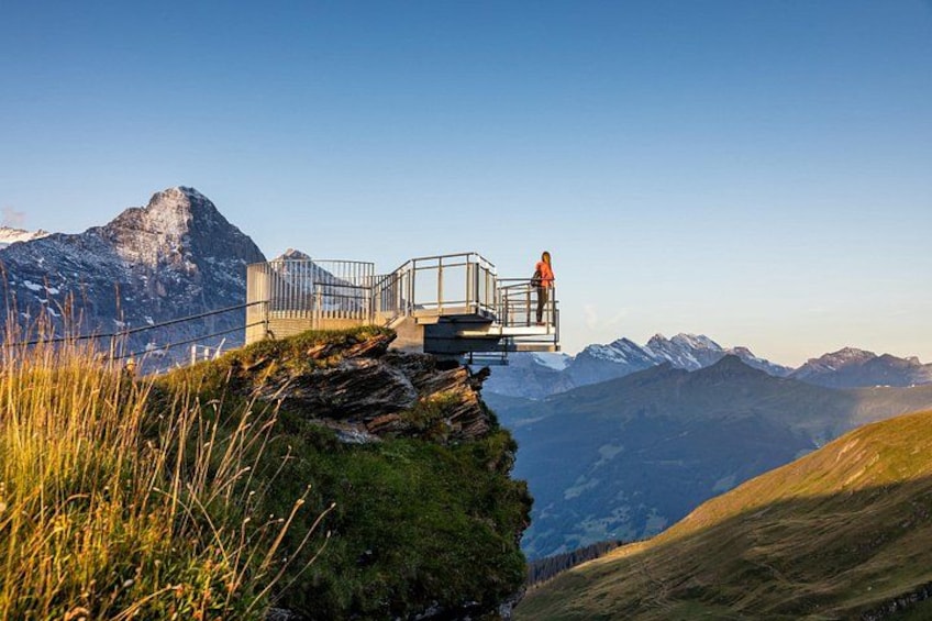 A person on a glass bridge overlooking a mountainous landscape. 5