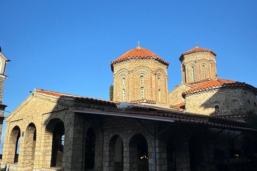Una iglesia con dos campanarios y fachada de piedra. 1