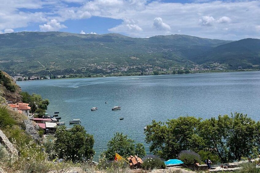 Un lago con barcos, un pueblo costero y montañas al fondo. 3