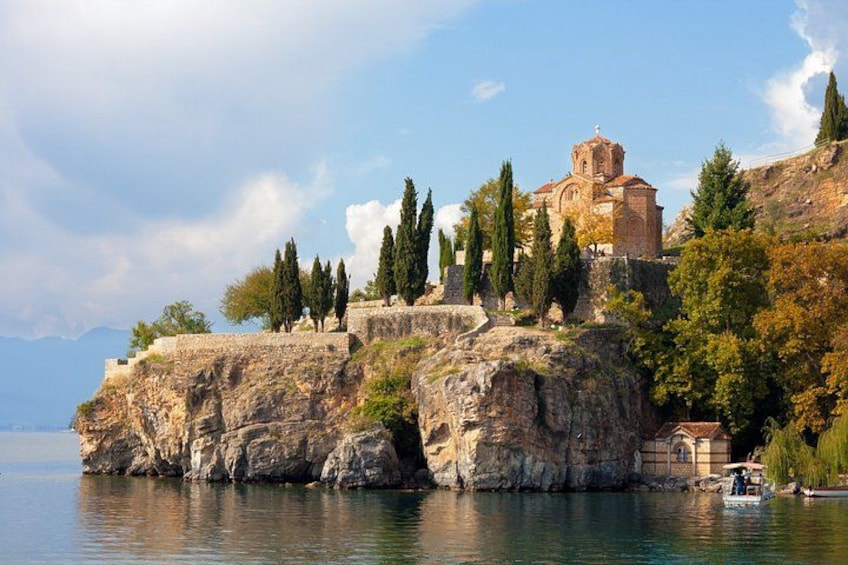 Una iglesia histórica sobre un acantilado rocoso frente a un lago tranquilo. 1