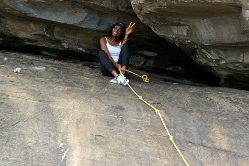 A person sitting on a rock with a rope. 5