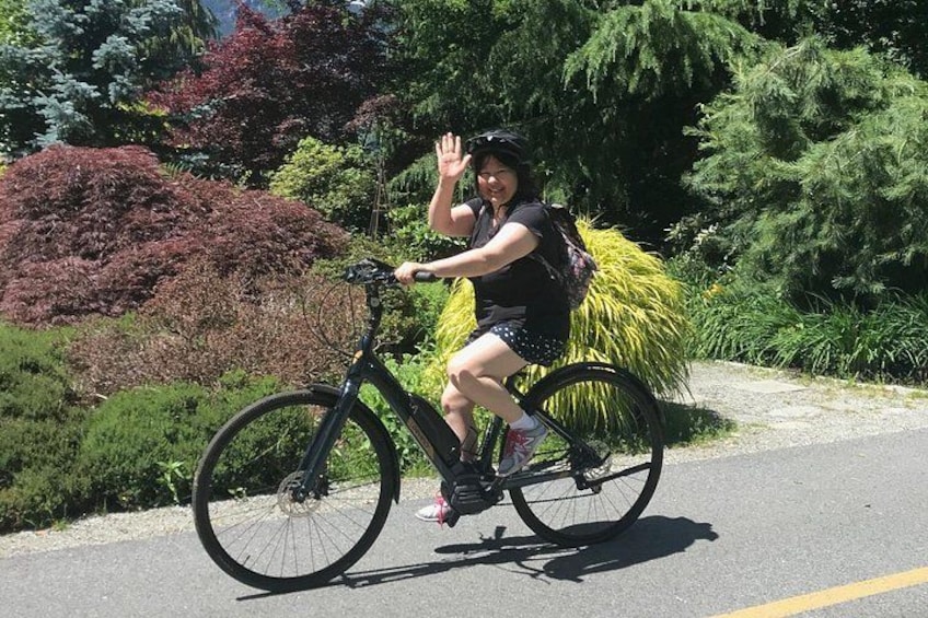 Eine Person fährt Fahrrad, auf dem Gepäckträger befindet sich eine große Pflanze. 4