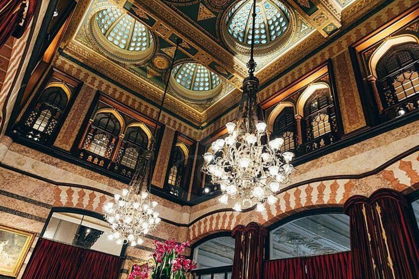 Un interior ornamentado con techos abovedados, candelabros y ventanas de arco. 4