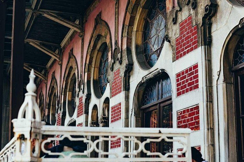 Un edificio con ventanas de arco y detalles en ladrillo rojo. 2