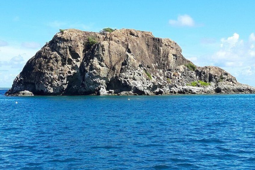 A rocky island with clear blue water. 5