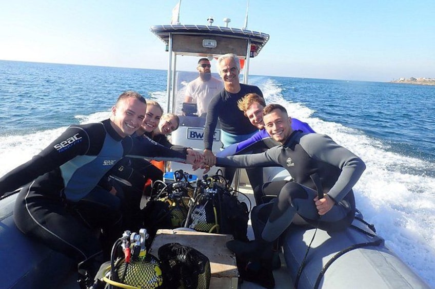 Un groupe de personnes se trouve sur un bateau, avec un ciel bleu clair et une mer calme en arrière-plan. 4