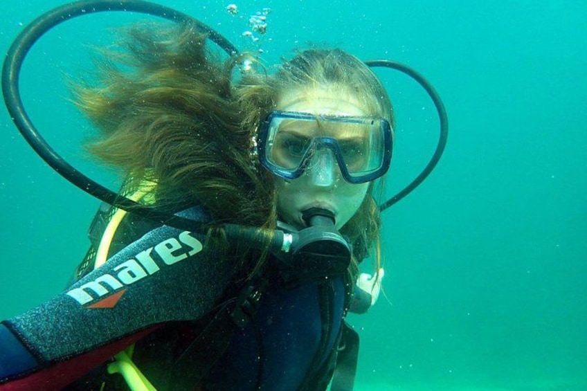 Une personne sous l’eau, équipée d’un équipement de plongée, notamment un masque et des palmes. 2