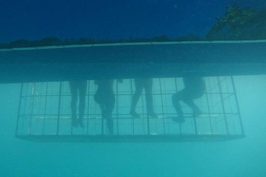 A pool with clear water, a tiled floor, and a shadow of a person. 2